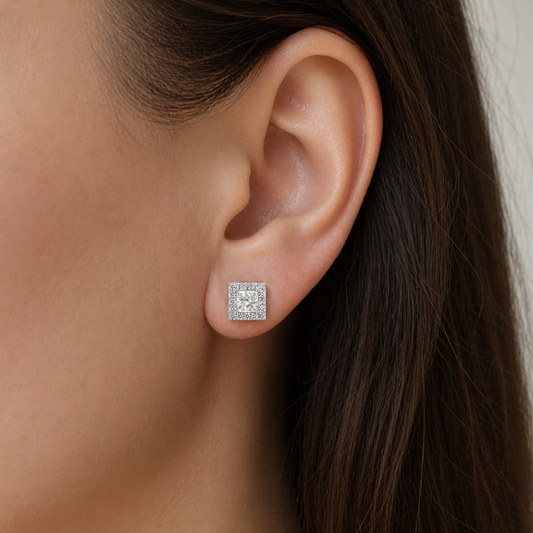 Close-up of an ear wearing a diamond stud earring with a neutral background