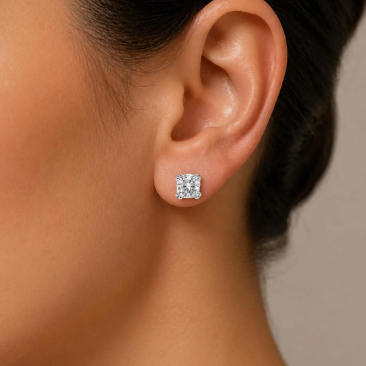 Close-up of an ear wearing a diamond stud earring with a neutral background