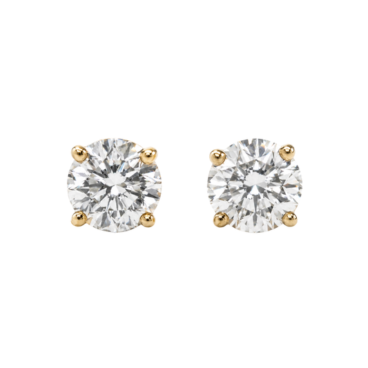 Pair of diamond stud earrings with yellow gold prongs on a white background