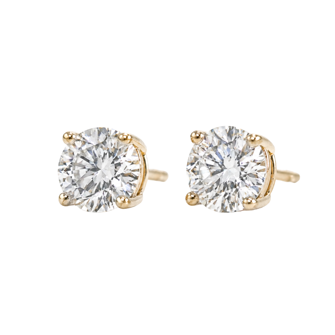 Pair of diamond stud earrings with yellow gold prongs on a white background side