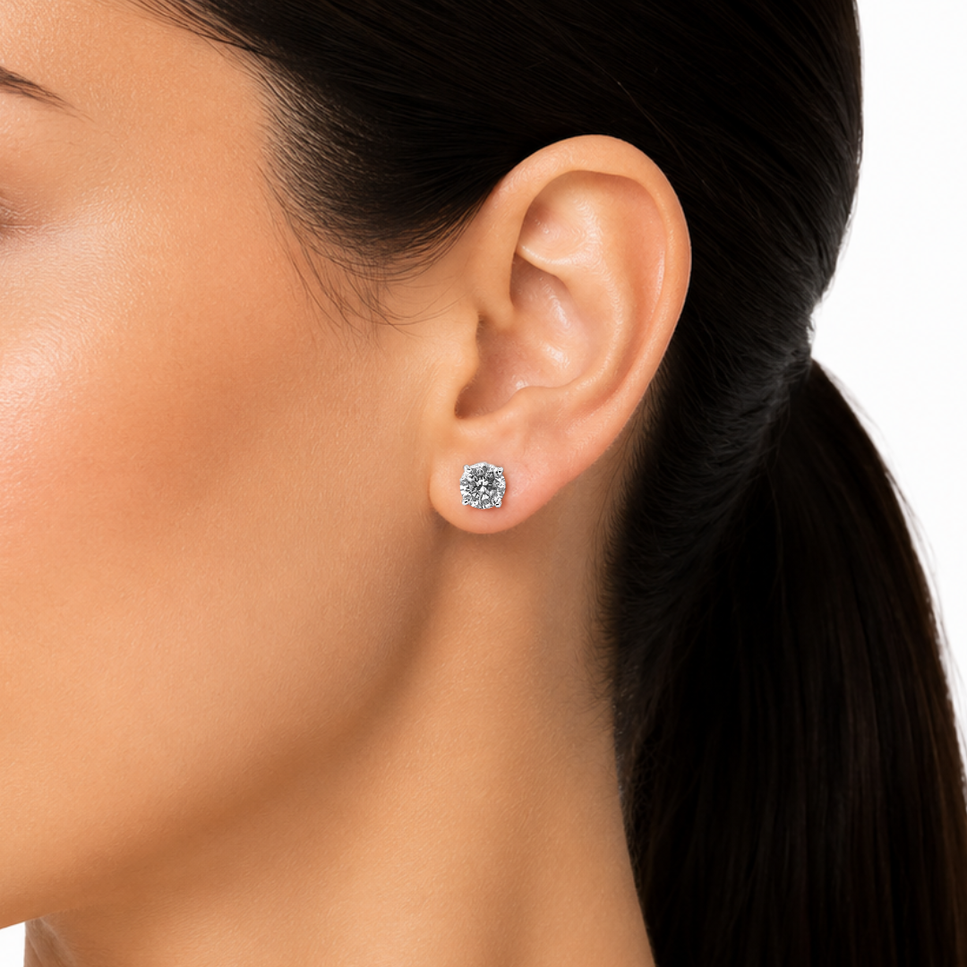 Close-up of an ear wearing a diamond stud earring with a blurred background