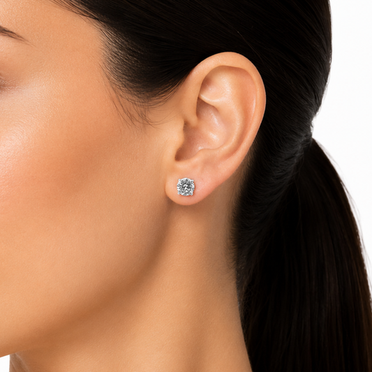 Close-up of an ear wearing a diamond stud earring with a blurred background