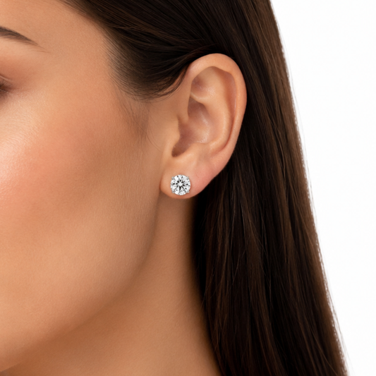 Close-up of an ear wearing a diamond stud earring with a blurred background
